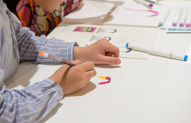Detail, ein Kind malt mit Bleistift ein Portrait im Rahmen von Schau hin! Bilder erzählen Geschichten. Rundgang mit interaktiven Elementen für Kinder, Foto: Daniel Schvarcz / Jüdisches Museum München  