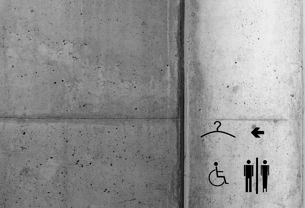 Piktogramme im Servicebereiche des Museums, darunter auch das Symbol für eine barrierefreie Toilette und Garderobe