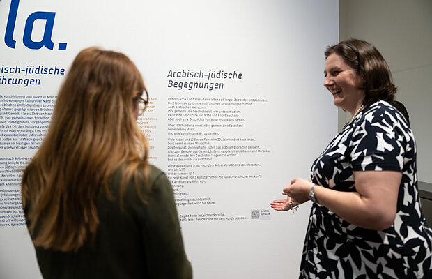 Besucher*innen stehen vor Texttafel in Leichter Sprache zur Ausstellung Yalla