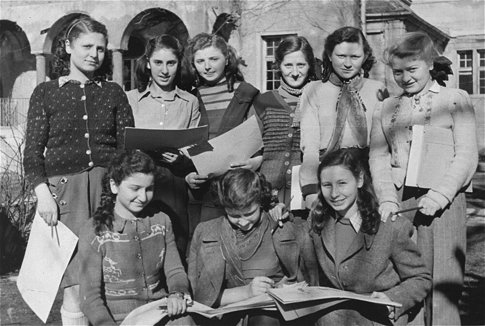 Schwarzweißfoto von Danuta Mandel (vorne links) mit Mitschülerinnen vor dem Hebräischen Gymnasium in der Möhlstraße, 1948 © USHMM