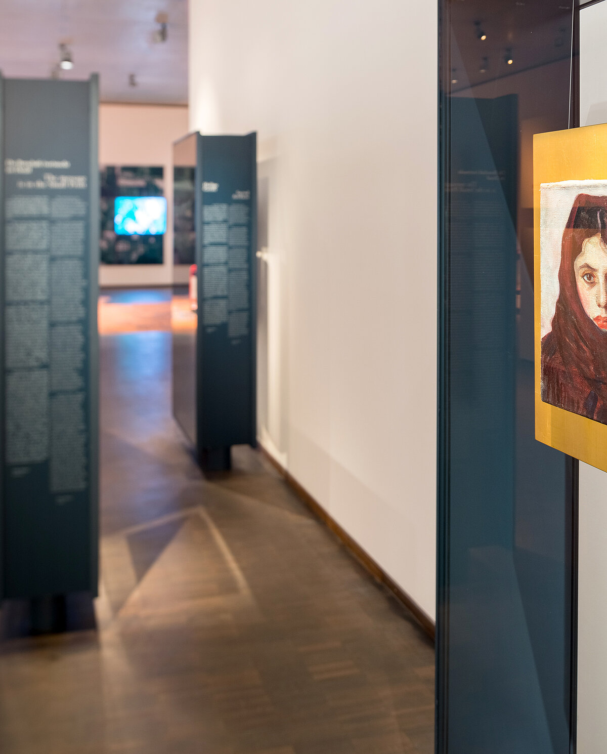 Blick in die Dauer-ausstellung mit einen leuchtend gelben Porträt im Vordergrund.