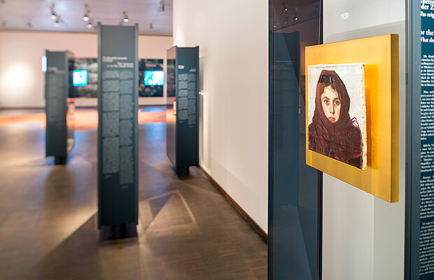 Blick in die Dauer-ausstellung mit einen leuchtend gelben Porträt im Vordergrund. 